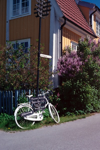 白色的城市自行车停在白色的木栅栏旁